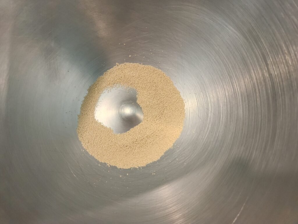 Active dry yeast added to a mixing bowl.