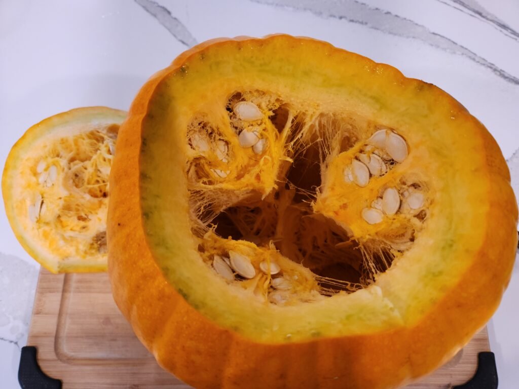 Pumpkin full of seeds with top removed.