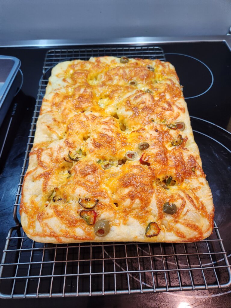 Focaccia bread cooling on wire rack.