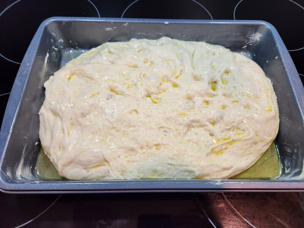Focaccia dough added to baking dish
