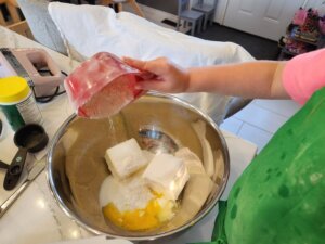 Child Adding Flour to Kourabiedes Batter