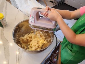 Child Using Hand Mixer to Mix Greek Christmas Cookie Dough