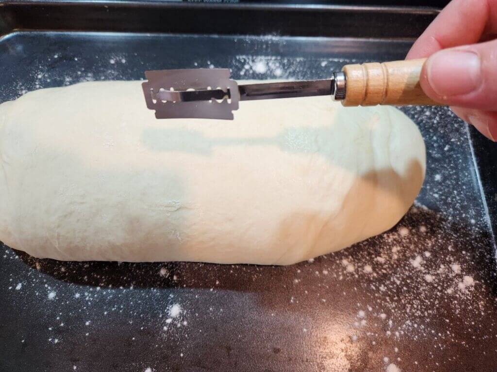 Ready to score fully proofed fresh bread with bread lame