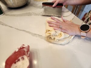 Working the dough to the desired consistency using scraper
