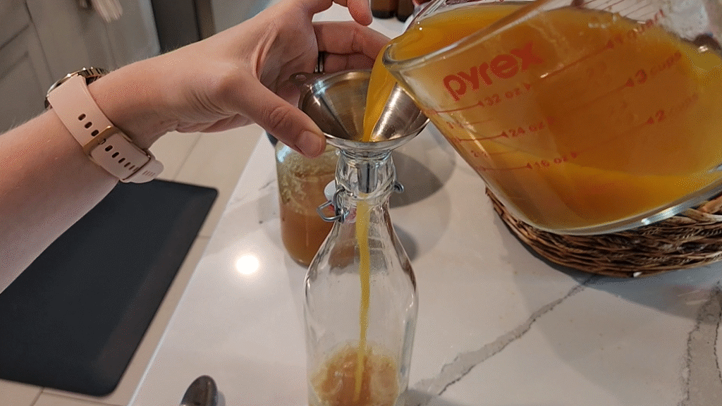Pouring Strained Fire Cider Into Vessel