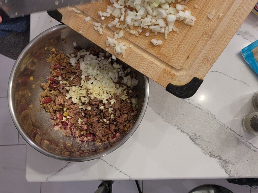Adding Chopped Onions and Garlic to Healthy Meatball Mixture