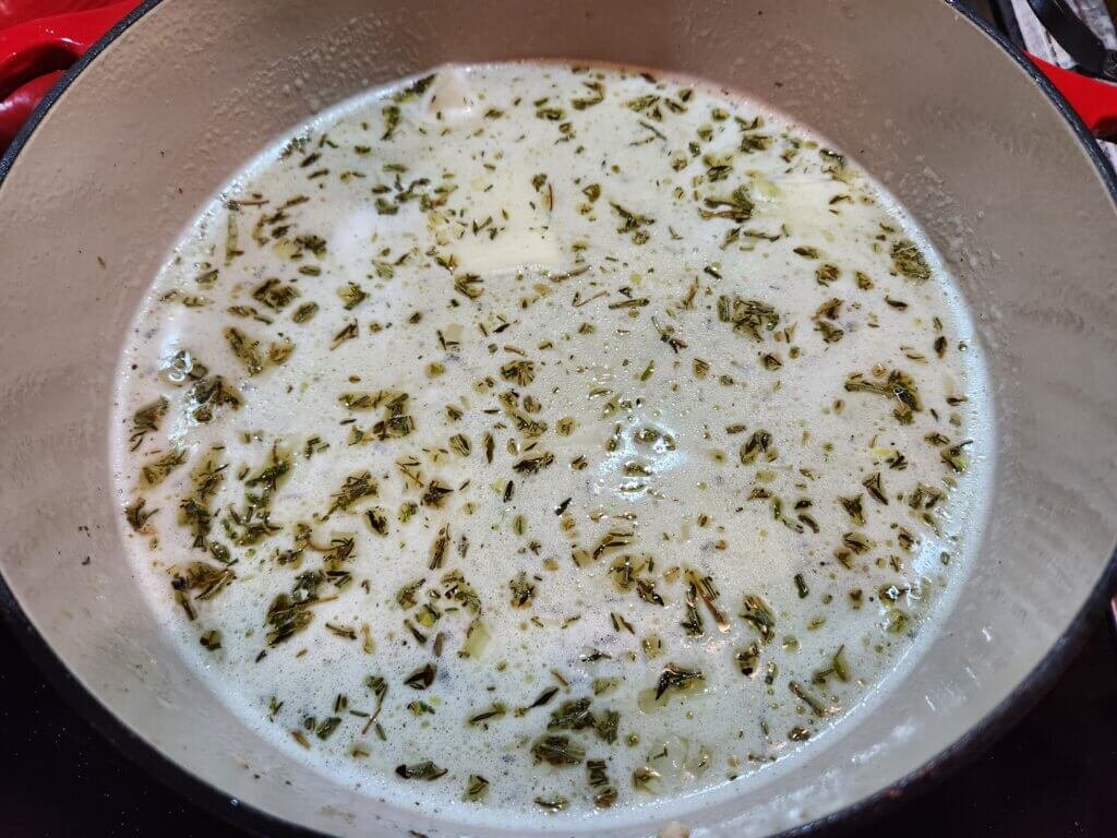 All ingredients of creamy chicken chowder simmering in a dutch oven.