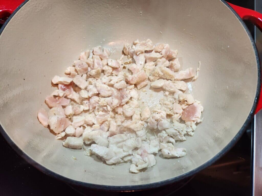 Cooking diced chicken in a dutch oven to make a creamy chicken chowder