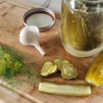 Finished fermented pickles after seven days with a cut pickle showing the inside